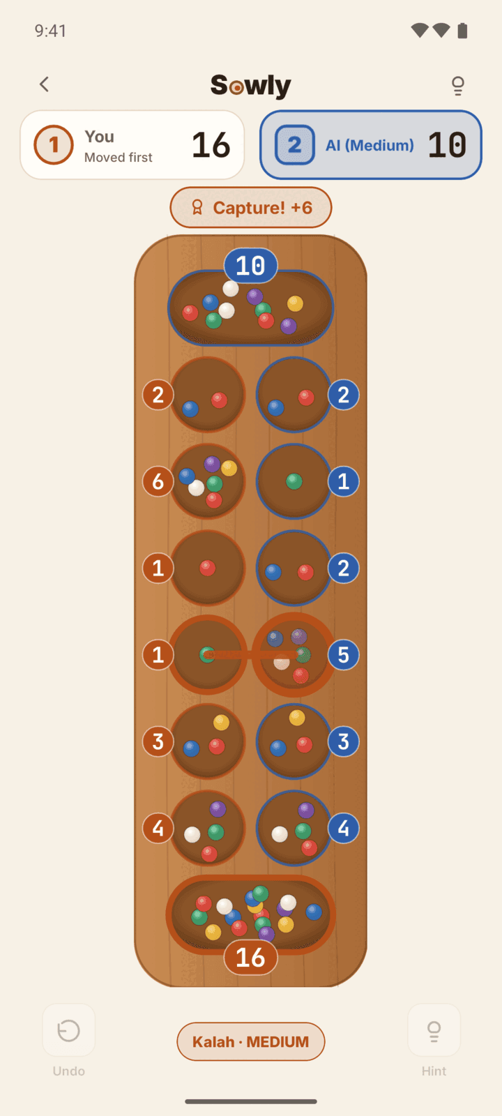 Sowly Kalah game on a wood board right after a capture of 6 seeds